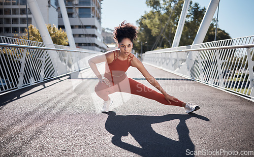 Image of Stretching legs, fitness portrait and woman on city bridge exercise, runner and training in sports shoes fashion. Warm up, focus and urban athlete on ground workout for body, muscle and health goals