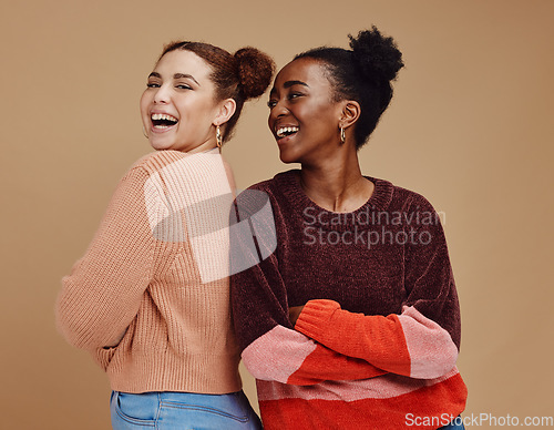 Image of Happy, smile and women friends in a studio together with fun, freedom and positive mindset. Happiness, excited and interracial girl best friends smiling with style while isolated by brown background.