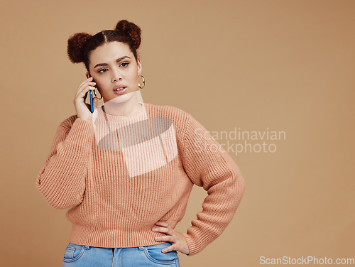 Image of Phone call, upset and woman in a studio with mockup space during an argument, fight or disagreement. Moody, communication and female model on a mobile conversation while isolated by brown background.