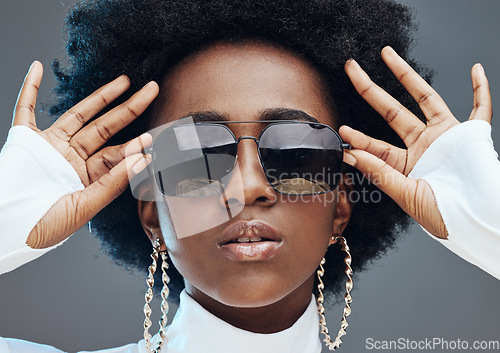 Image of Face zoom, sunglasses and fashion with black woman, style and designer with trendy brand and gen z hands against studio background. Jewelry, edgy and girl, marketing with fashion model and beauty