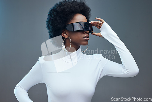 Image of Futuristic sunglasses, fashion and black woman, young gen z and stylish with trendy designer brand against studio background. Model, cyberpunk and natural curly hair with beauty and edgy style