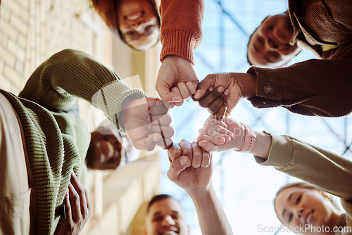 Image of Below, students and fist hands in group for support, motivation or education in sunshine at college. Diversity, fist bump and community with teamwork, studying or scholarship at university for future