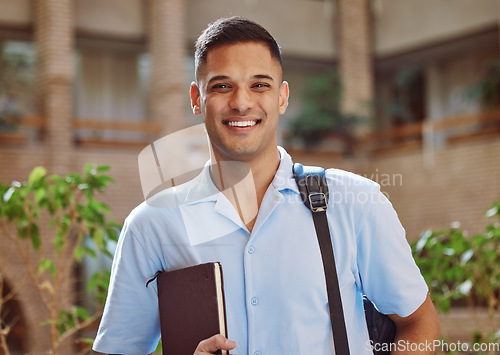 Image of Face portrait, man and university student in campus ready for learning. Education, college and happy male learner from Brazil holding book for knowledge, studying and literature research outdoors.