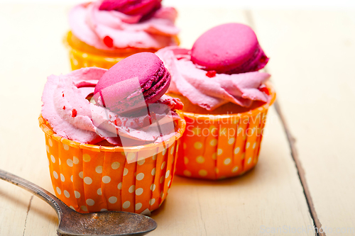 Image of pink berry cream cupcake with macaroon on top