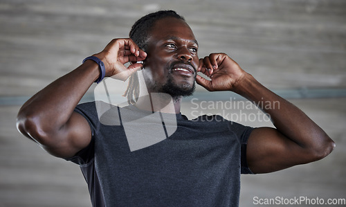 Image of Exercise, black man and earbuds for music, wellness and motivation for fitness, cardio or muscle power. African American male, athlete or earphones for podcast, radio or workout to relax or streaming