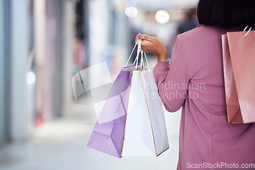 Image of Woman, shopping bag and walking in a mall for retail therapy, sale and customer discount at a store. Hand of fashion female at commercial shop buying clothes on promotion for commerce on travel