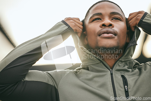 Image of Exercise, mindset and hoodie with a sports black man getting ready for a workout, fitness or running. City, health and goal with a male athlete or runner outdoor in an urban town with motivation