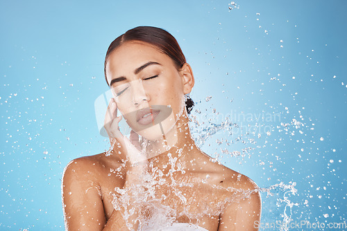 Image of Woman skincare, hand or water splash face on blue background studio in healthcare wellness, Brazil hygiene maintenance or bathroom grooming. Beauty model, shower or wet water drop for facial cleaning