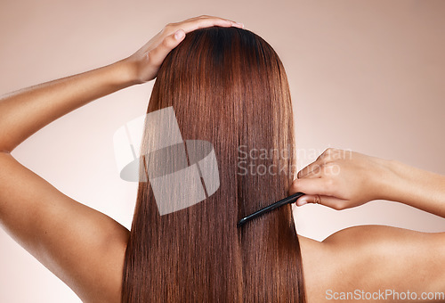 Image of Hair, salon and back of woman with comb for hair care, hair products and cosmetics on beige background studio. Beauty, hairdresser and girl with healthy long hair for hair salon, treatment and shine