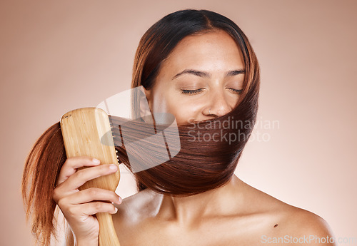 Image of Hair care, beauty and brush with a woman brushing after salon, hairdresser or shampoo treatment in studio. Face of aesthetic female model grooming clean hair in studio for health and wellness mockup