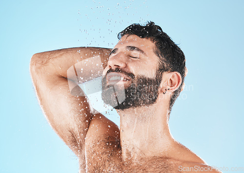 Image of Shampoo, shower and cleaning with a model man washing his hair in studio on a blue background for natural care. Keratin, treatment and water with a male wet in the bathroom while grooming alone