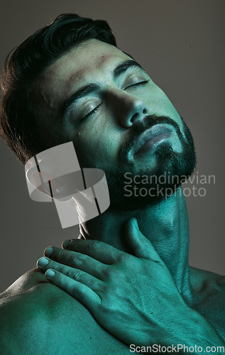 Image of Man, face and neon with beauty and skincare, grooming and wellness with eyes closed against studio background. Healthy skin, relax in blue light and peace, male and cosmetic facial and treatment