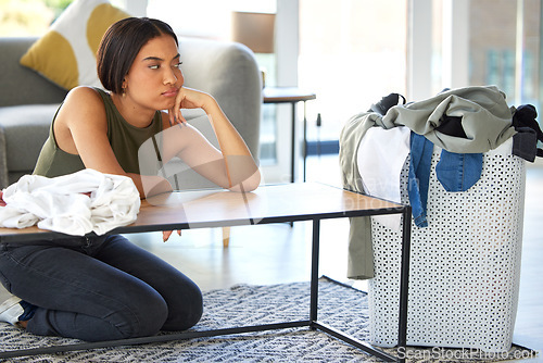 Image of Bored, sad and woman cleaning laundry, housework stress and tired of chaos in the living room. Frustrated, anxiety and cleaner organizing washing clothes, housekeeping and problem with chores