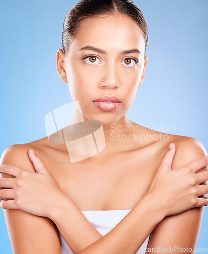 Image of Skincare, beauty and portrait of a woman in a studio for natural, self care and body care treatment. Health, wellness and girl model from Brazil with a facial routine isolated by a blue background.