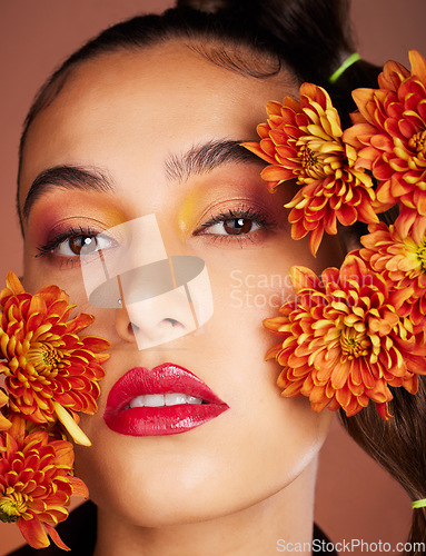 Image of Makeup, beauty or woman in studio with flowers for art fashion and natural facial cosmetics for self care. Face portrait, orange plants or girl model with red lipstick, eyeshadow and glowing skin