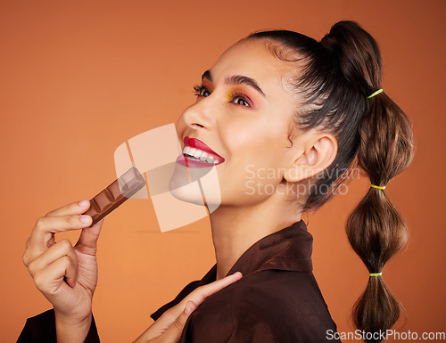 Image of Beauty, eating and profile woman with chocolate bar, junk food or dessert for sugar sweets, candy snack or cheat meal. Face makeup, skincare cosmetics and hungry hair model with brown cacao product