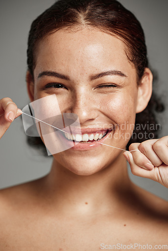 Image of Teeth flossing, dental floss and portrait of woman with a smile in studio for oral hygiene, health and wellness. Face of happy female on grey for self care, healthcare and grooming for healthy mouth