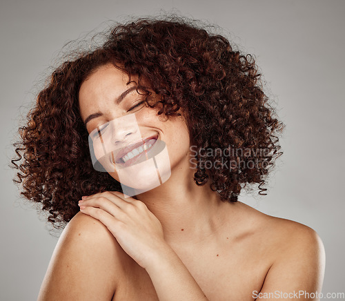 Image of Face, happy and skincare with a model black woman in studio on a gray background to promote natural care. Facial, wellness and makeup with an attractive young female touching her soft beauty skin