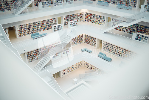 Image of Library, research and education with books in an empty room with stairs to a floor on university or college campus. Learning, study and scholarship with book shelves in a school for development