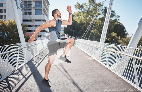 Image of Fitness, running and exercise with a sports man on a bridge in the city for a cardio or endurance workout. Health, runner and training with a male athete exercising in an urban town for wellness