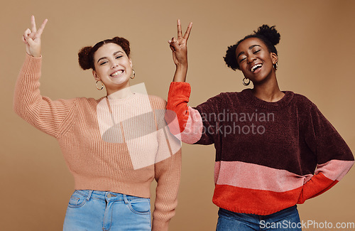 Image of Diversity, peace sign and women friends in studio with hand gesture, smile and happiness on brown background. Fashion, cosmetics and black woman with girl for relax, lifestyle and happy together