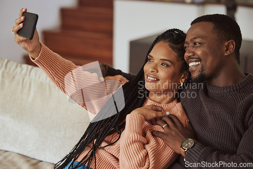 Image of Black couple, phone selfie and love while together on home couch with care and happiness in a happy marriage. Young man and woman with a smile for social media while bonding in an apartment lounge