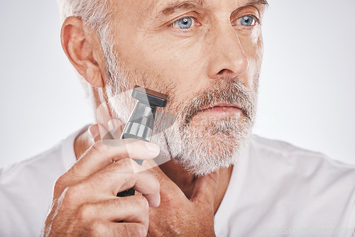Image of Senior man, shaving facial hair and grooming beard for skincare, hygiene and wellness with dermatolgy cosmetics. Hair removal, epilation and beauty of elderly male cleaning face on studio background