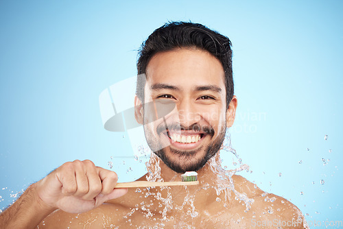 Image of Water splash, portrait or man brushing teeth in studio with toothbrush for white teeth or dental healthcare. Bamboo wood, sustainable or happy person cleaning or washing mouth with a healthy smile