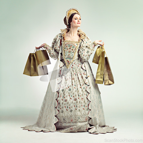 Image of Queen, fashion bags and woman shopping in studio isolated on a gray background mockup. Royalty, sales deals and rich and wealthy female ruler holding luxury golden gifts after purchase at royal mall.