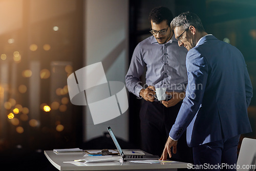 Image of Businessman, colleagues and laptop at office in night for strategy, goals and target for investment in stock market. Stock broker team, reading and computer with innovation, working late and focus