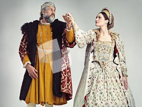 Image of Medieval, love and king with queen in studio on gray background for power, ruler and leadership. History, theatre and isolated royal couple holding hands in vintage, renaissance and Victorian cosplay