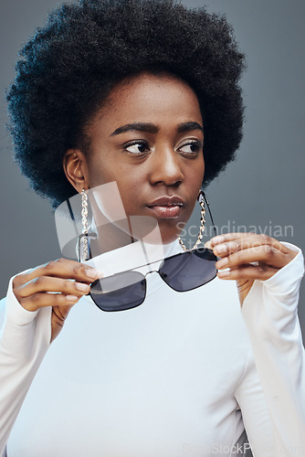 Image of Fashion, beauty and black woman with sunglasses in studio for cosmetics, makeup and luxury style. Fashion model, designer brand and confident girl with stylish accessories, trendy and edgy jewellery
