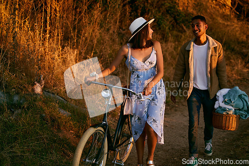 Image of Romantic, happy and couple on a picnic in a park for a date, holiday and love in Indonesia. Travel, smile and man and woman walking in nature for romance, peace and relax with food during sunset