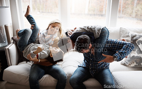 Image of Playful, funny and family on the sofa with energy for fun, playing and bonding in their house. Relax, happy and parents with crazy children to play wrestle on the couch during quality time in a home