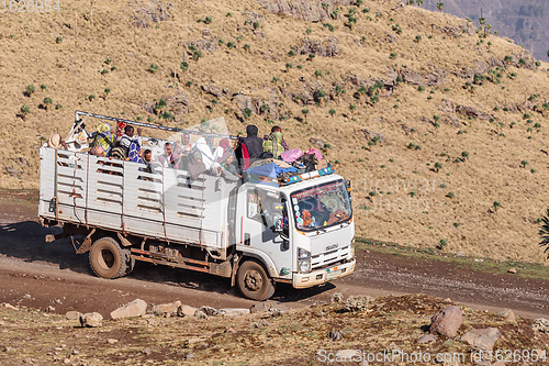 Image of People traveling dangerously on truck