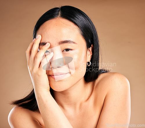 Image of Portrait, beauty and skincare with a model asian woman in studio on a beige background for natural treatment. Wellness, aesthetic or facial with an attractive young female posing to promote antiaging