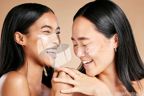 Image of Happy, beauty and skincare women with cream for face isolated on a beige studio background. Wellness, smile and Asian model friends with sunscreen for love of cosmetics and dermatology on a backdrop