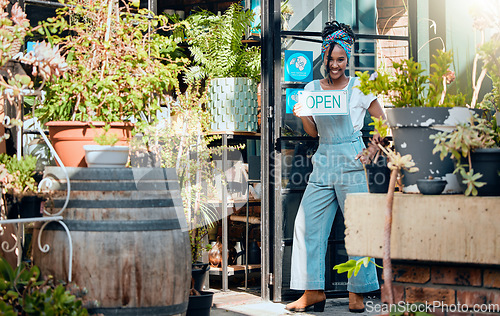 Image of Open sign, small business or black woman in flowers store with advertising board in organic nursery. Welcome, agro manager or happy entrepreneur with a smile opening a floral or plants retail shop