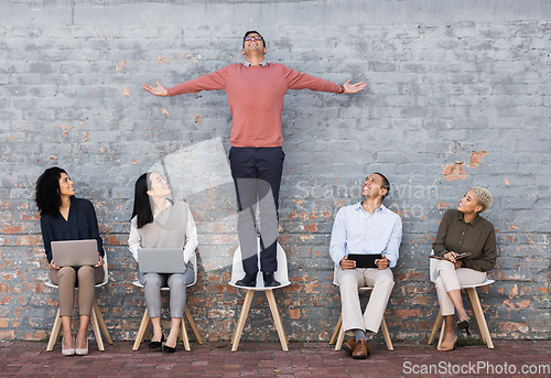 Image of Business people, waiting room and man standing out for interview, meeting or opportunity against a brick wall. Group of employee workers or interns with technology looking at candidate on chair