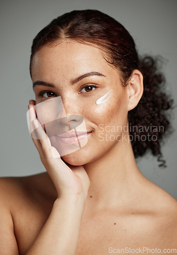 Image of Face portrait, skincare and woman with cream in studio isolated on a gray background. Cosmetics, beauty and young female model with lotion product, creme or moisturizer for healthy skin and wellness.