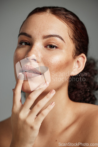 Image of Face, sugar scrub and lips of woman in studio isolated on a gray background. Portrait, cosmetics and skincare of female model with lip dermatology product for exfoliation, cleaning and healthy skin.