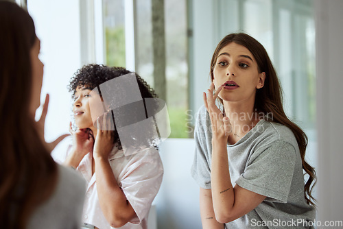 Image of Women doing skincare in bathroom, friends grooming to relax and apply makeup together in luxury hotel. Looking in the mirror, beautiful girls with cosmetic facial treatment and self care routine