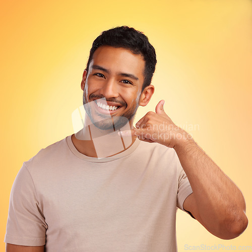 Image of Portrait, call me hands and man in studio isolated on a yellow background. Face, fashion and happy male model with cool hand gesture for shaka sign, symbol or emoji for communication and connection.
