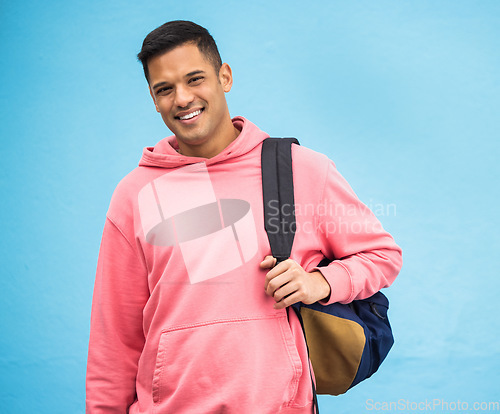 Image of University, student and portrait of man with backpack in studio, happy and smile on blue background. Face, handsome and college student excited about education, vision and career goal while isolated