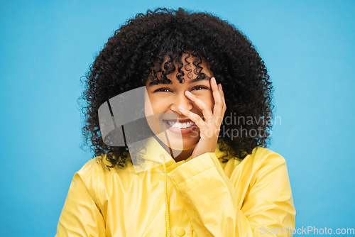 Image of Portrait, laugh and funny with a black woman on a blue background, laughing at a joke in studio. Face, happy and smile with an attractive young afro woman enjoying humor or fun against a color wall