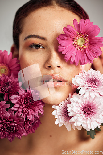 Image of Woman, flowers and studio portrait for beauty, wellness and skincare with spring aesthetic by background. Model, girl and carnation plant with cosmetic health, natural skin glow and symbol for growth