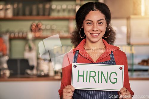 Image of Portrait, small business or black woman with hiring sign for onboarding in a cafe or coffee shop with hospitality. Restaurant manager with a happy smile with recruitment message after opening store