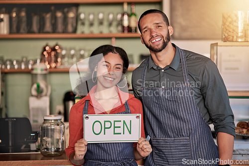 Image of Portrait, small business or couple with open sign to welcome sales in a cafe or coffee shop with hospitality. Restaurant or managers with a happy smile with message on board after opening a store