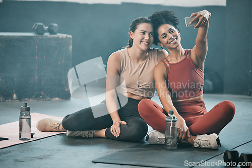 Image of Happy woman, friends and fitness with phone for selfie, moments or picture in workout exercise or training at gym. Sporty women with smile looking at smartphone for photo or healthy wellness together