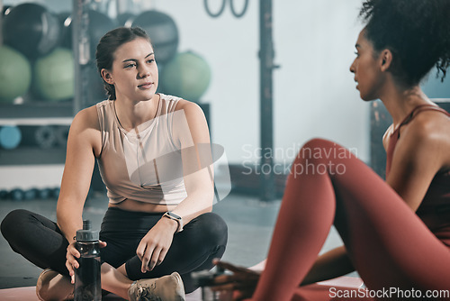 Image of Relax, friends or women at gym talking about fitness training goals, workout progress or exercise on a break. Resting, sports girl and healthy black woman in conversation, discussion or speaking